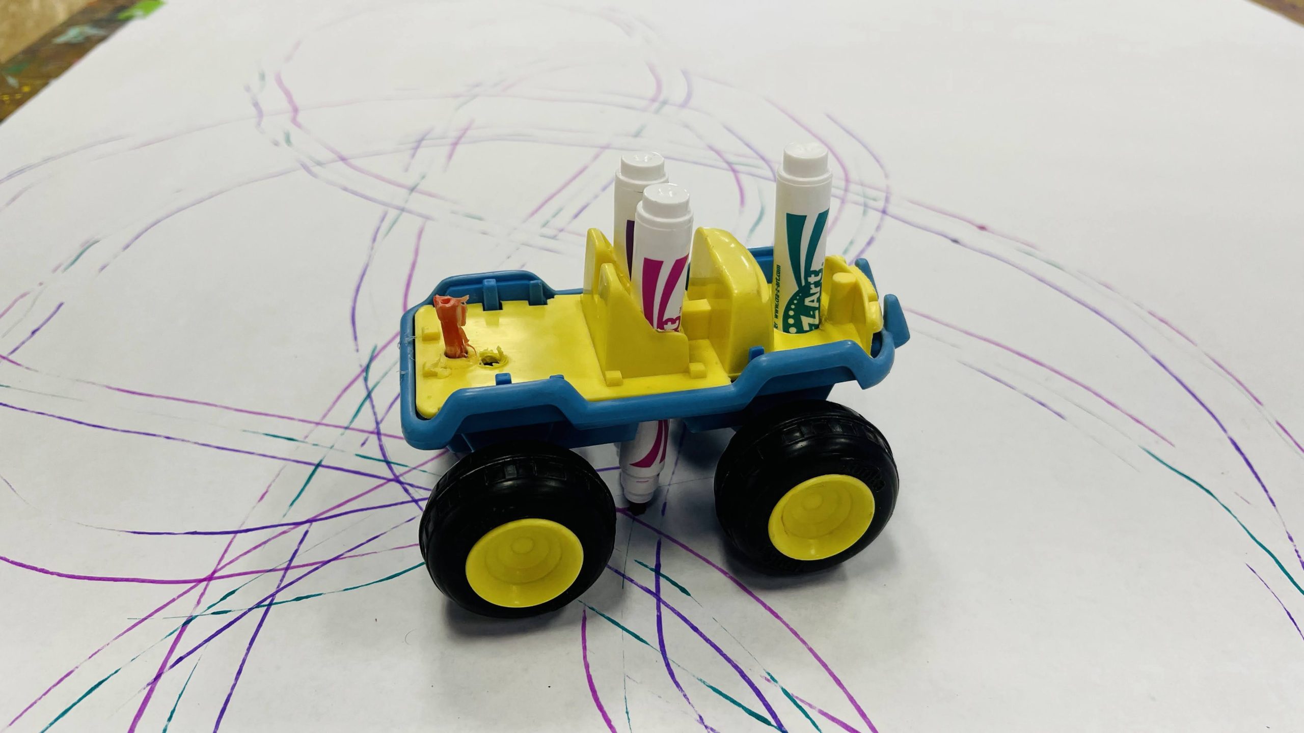 Toys and toy vehicles modified with marker holders turn pushing and driving into broad, energetic lines and abstract patterns into a reality.